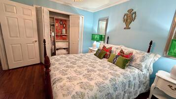 A bedroom with a bed, a wardrobe, a mirror, and a chandelier.