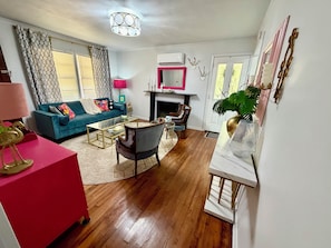 A living room with a blue sofa, a red table, and a fireplace. - Cozy  vintage style 3 bedroom  1 bath home in beautiful Water Valley (Water Valley)