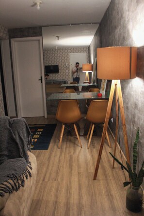 A dining area with a table, chairs, and a lamp.