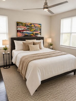 A bedroom with a bed, a ceiling fan, a painting, and a window with blinds. - Newly refurbished, private home with open layout and backyard (Sarasota)