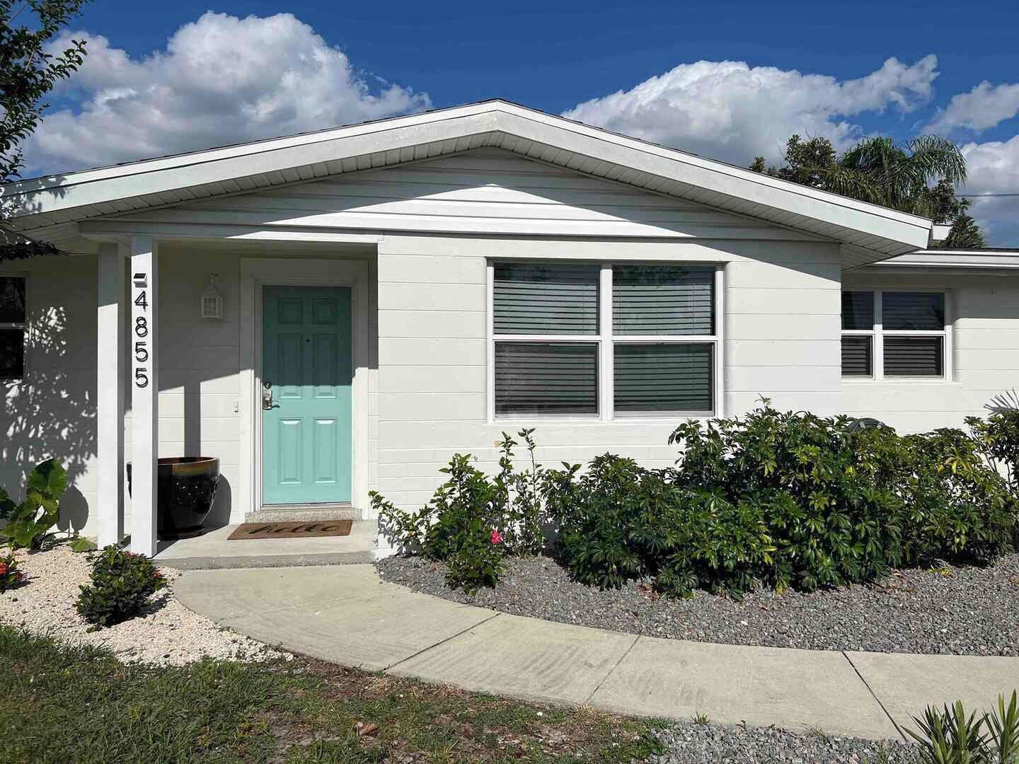 A single-story house with a front door, a mailbox, and a number '4855' on the wall.