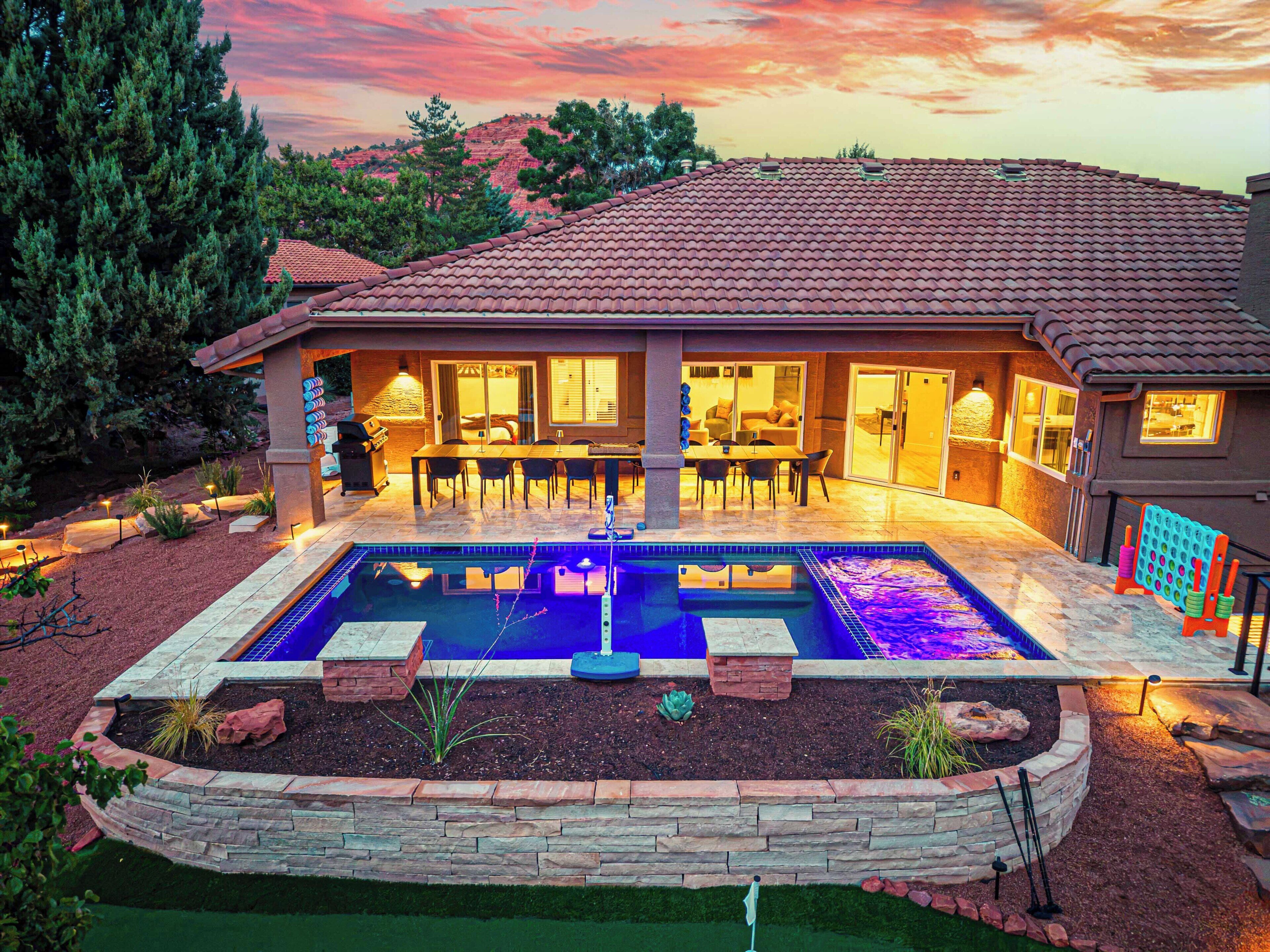 Ein Haus mit Swimmingpool, Terrasse und Sitzgelegenheit im Freien.