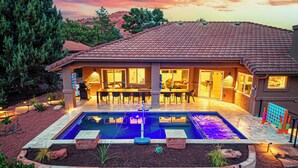 Ein Haus mit Swimmingpool, Terrasse und Sitzgelegenheit im Freien.