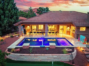 Ein Haus mit Swimmingpool, Terrasse und Sitzgelegenheit im Freien.