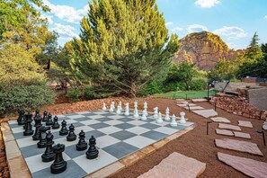 A chessboard set outdoors with a mountainous backdrop. - The Yucca House: Pool, Spa, Gym, Theater, Game Room | Epic Red Rock Views (Sedona)
