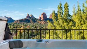 A hot tub with a mountain view, a balcony railing, and trees. - Epic Red Rock Views, Hot Tub, Walk to Uptown (Sedona)