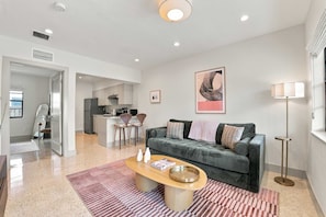 Un appartement moderne comprenant un salon, une cuisine et un coin repas.
