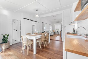 A modern kitchen with a wooden countertop, a sink, and a hanging light fixture.