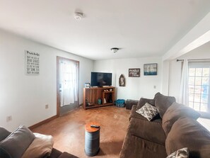 Ein Wohnzimmer mit einer Couch, einem Fernseher und einem Couchtisch.