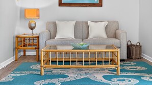 A living room with a sofa, a coffee table, a lamp, and a framed map on the wall. - Bayside - Islamorada Waterfront, 360 Viewing Deck, Htd Swim Spa (Islamorada)