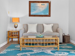 Ein Wohnzimmer mit einer Couch, einem Couchtisch, einer Lampe und einer gerahmten Karte an der Wand.