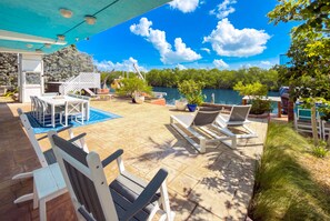 Eine Terrasse im Freien mit Pool, Liegestühlen und Essbereich.