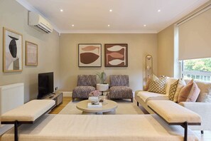 A modern living room with a sofa set, a coffee table, and artwork on the walls. - Well Placed in the Wood (Greater London)