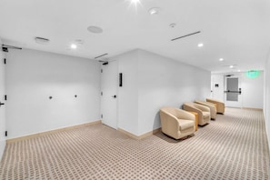 A hotel lobby with a reception desk, a waiting area with chairs, and a patterned carpet. - District 225 - Brand New Downtown Apartment (Miami)