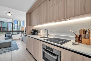 A modern kitchen with a built-in oven, a coffee maker, and a sink. - District 225 - Brand New Downtown Apartment (Miami)