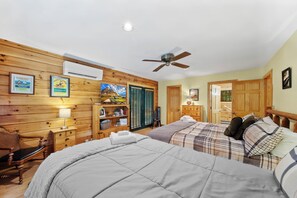 A bedroom with two beds, wooden walls, a ceiling fan, and a door leading to another room. - Cozy A-Frame Steps from Downtown Banner Elk (Banner Elk)