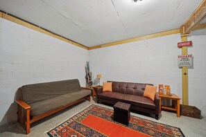 A room with a brown sofa, a smaller couch, a patterned rug, and a sign warning of poker players and loose women. - Cozy A-Frame Steps from Downtown Banner Elk (Banner Elk)