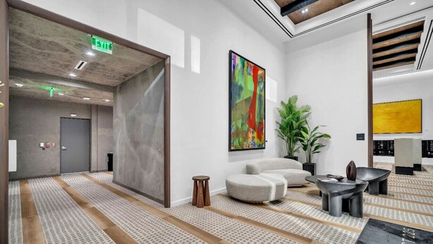 A modern lobby with a seating area, a large abstract painting, and a plant. - Brand New Building & Amazing Amenities (Miami)