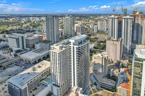 Une vue urbaine avec de hauts immeubles, dont certains sont en construction, et un ciel dégagé.