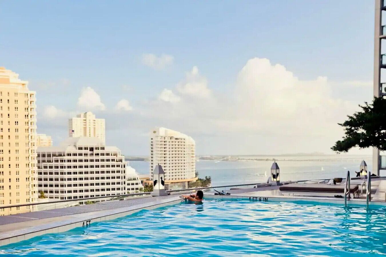Una piscina con vista al horizonte urbano y al océano.