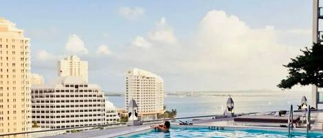 Una piscina con vista al horizonte urbano y al océano.