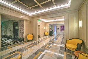A hotel lobby with a checkered floor, yellow chairs, and a modern ceiling design. - Basquiat Brickell Luxury Retreat (Miami)