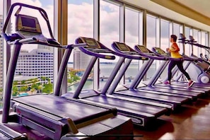 A gym with treadmills, a stationary bike, and a rowing machine. - Basquiat Brickell Luxury Retreat (Miami)