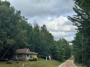 Ein Haus mit Veranda, Picknicktisch und Fahnenmast mit US-amerikanischer Flagge.