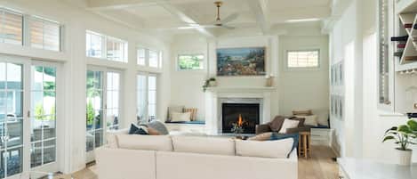A spacious living room with a fireplace, a large sofa, and a dining area.