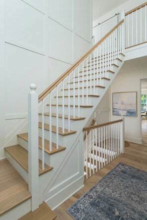 Eine Treppe mit Holzdielen und weißen Geländern.