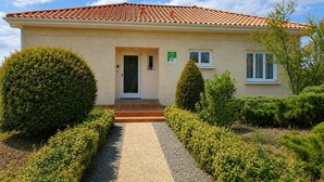 Ein zweistöckiges Gebäude mit einem Ziegeldach, einer Haustür und einem kleinen Fenster.