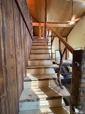 A wooden staircase with a rustic design, leading to a lower level. - Creekside cabin in heart of the Cherokee National Forest on 4 private acres (Reliance)