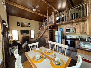 A rustic interior with a dining area, kitchen, and a staircase. - Creekside cabin in heart of the Cherokee National Forest on 4 private acres (Reliance)