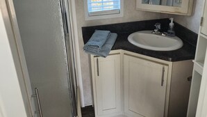 Une petite salle de bain comprenant une douche, un lavabo et des toilettes.