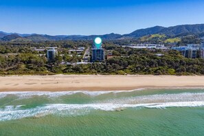 A coastal area with a beach, ocean, and hills in the background. - Kai - Penthouse Luxury with breathtaking Ocean views (Coffs Harbour)