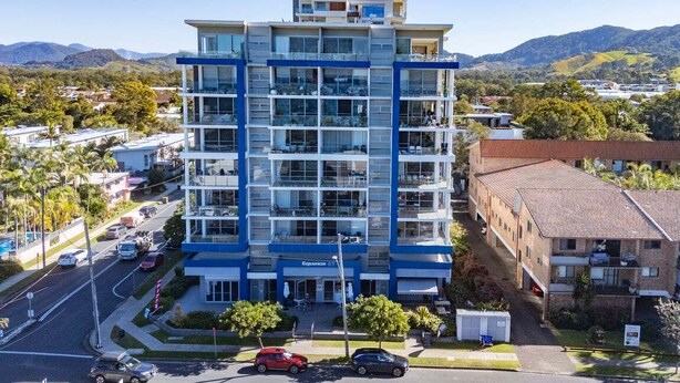 A multi-story hotel with a modern design, featuring balconies on each floor, located in a hilly area with clear skies. - Kai - Penthouse Luxury with breathtaking Ocean views (Coffs Harbour)