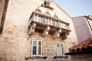 A stone building with a balcony, two windows with shutters, and a red-tiled roof. - Villa Ljuba - Private villa with pool, Hvar (Hvar)