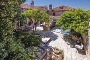 A courtyard with stone flooring, outdoor seating, and greenery. - Villa Ljuba - Private villa with pool, Hvar (Hvar)