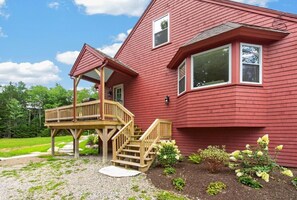 A red house with a wooden deck and stairs leading to a covered porch. - Family Friendly Home Just Minutes from Boothbay Harbor! (Boothbay)