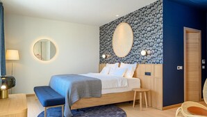 Quarto moderno com cama, mesas de cabeceira, espelho redondo e detalhe decorativo circular na parede.