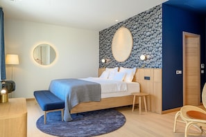 Ein modernes Schlafzimmer mit einem Bett, Nachttischen, einem runden Spiegel und einer Wand mit einem dekorativen, runden Element.