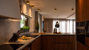 Una cocina moderna con armarios de madera, encimera negra y una lámpara colgante.
