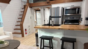 A modern kitchen with a wooden countertop, stainless steel appliances, and a built-in oven.