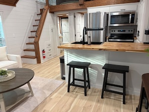Una cocina moderna con encimera de madera, electrodomésticos de acero inoxidable y horno empotrado.