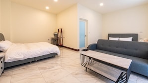 Une chambre à coucher avec un lit, une commode, un miroir et une porte.
