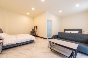 A bedroom with a bed, a dresser, a mirror, and a door.