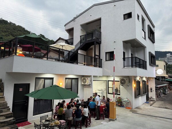 Un edificio de varios pisos con mesas al aire libre y una escalera.