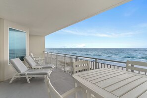 Ein Balkon mit weißer Möbel, Blick aufs Meer und klarer Himmel.