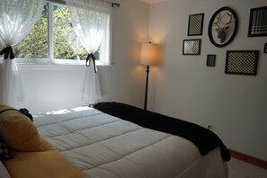 A bedroom with a bed, a bedside lamp, and a window with sheer curtains. - Modern 3 bedroom in nice location.   Less than 2 miles to Downtown. (Boulder)