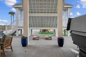 A covered patio area with a pergola structure, outdoor seating, and a view of the surrounding landscape. - Luxury Pet Friendly Gulf Retreat with Pool + Hot Tub, Game Room and Putting Green | Sleeps 22 (Port Bolivar)